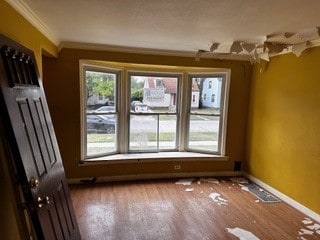 empty room with ornamental molding and hardwood / wood-style floors