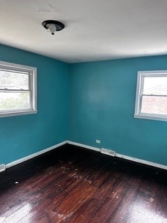 spare room with a healthy amount of sunlight and hardwood / wood-style floors