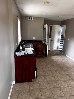 kitchen featuring kitchen peninsula, tile patterned floors, and sink