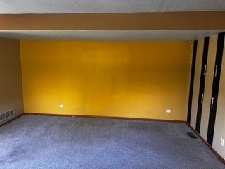 unfurnished room with a textured ceiling and carpet