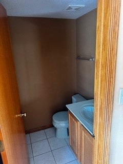 bathroom featuring vanity, toilet, and tile patterned flooring