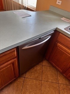 room details with dishwasher, light tile patterned flooring, and radiator