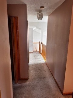 hall with a textured ceiling and carpet