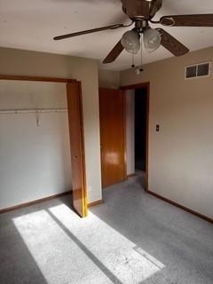 unfurnished bedroom with ceiling fan, a closet, and light colored carpet