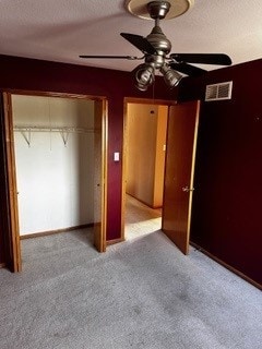 unfurnished bedroom featuring ceiling fan, a closet, and carpet