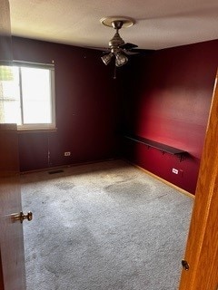 empty room with ceiling fan and carpet