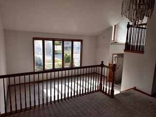 stairway featuring vaulted ceiling and carpet floors