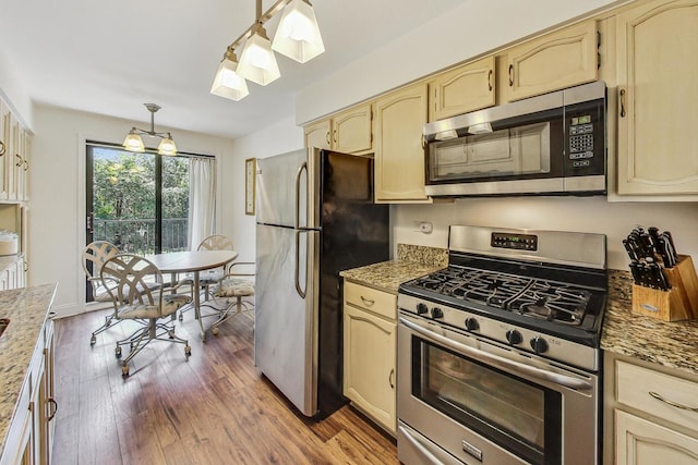 kitchen featuring hanging light fixtures, appliances with stainless steel finishes, an inviting chandelier, and dark wood-type flooring