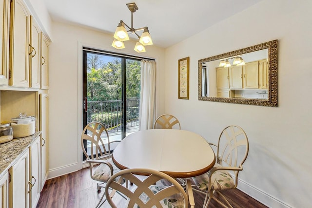 dining area with dark wood-type flooring and a notable chandelier