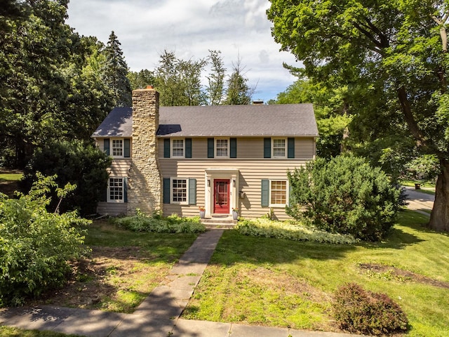 colonial inspired home featuring a front lawn