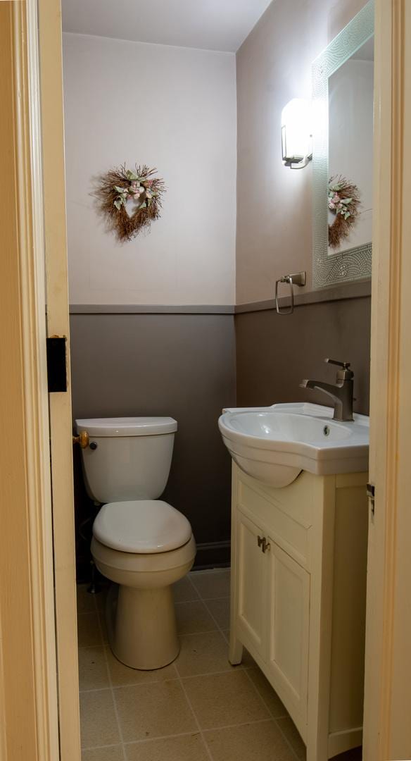 bathroom featuring tile patterned flooring, vanity, and toilet