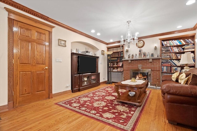 living room with crown molding, recessed lighting, a brick fireplace, wood finished floors, and baseboards