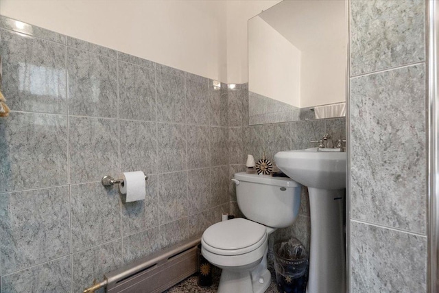 half bathroom with toilet, tile walls, and baseboard heating