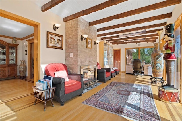 living area featuring beamed ceiling and wood finished floors