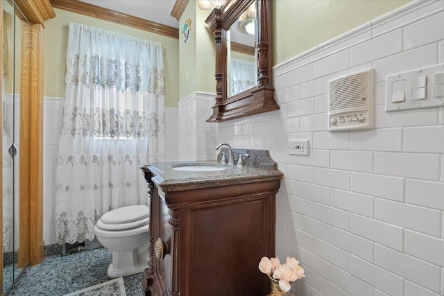 bathroom with toilet, a wainscoted wall, curtained shower, vanity, and tile walls