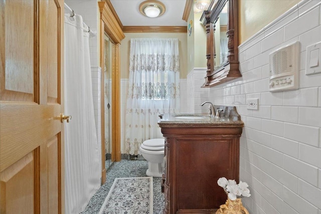 bathroom featuring wainscoting, toilet, ornamental molding, vanity, and tile walls