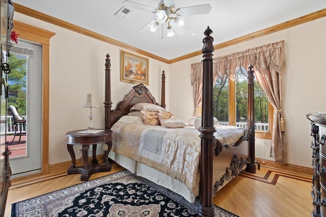 bedroom featuring ceiling fan, wood finished floors, visible vents, baseboards, and ornamental molding