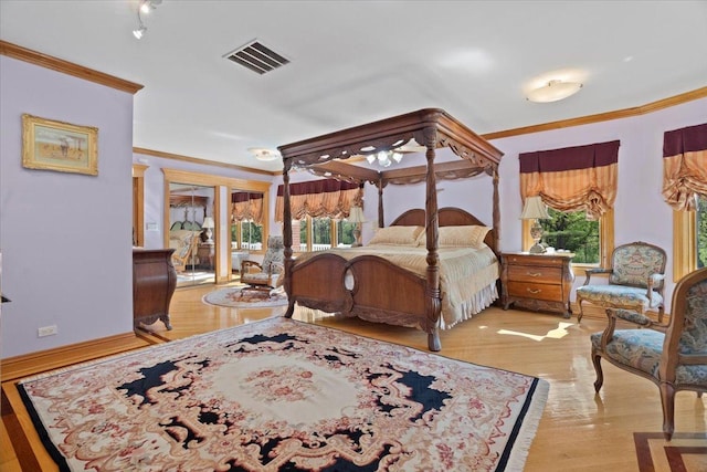 bedroom with multiple windows, visible vents, and ornamental molding