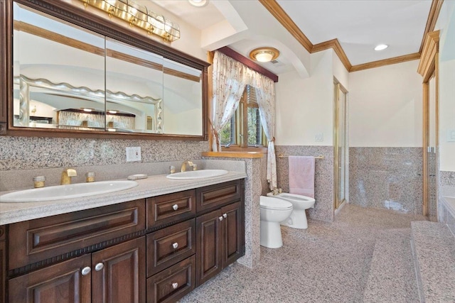 bathroom featuring wainscoting, a bidet, a sink, and tile walls