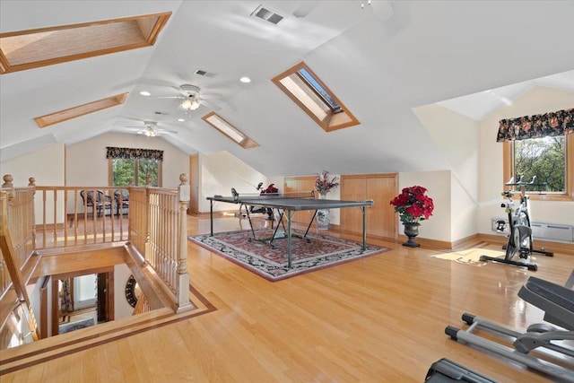 office area featuring lofted ceiling with skylight, visible vents, and wood finished floors