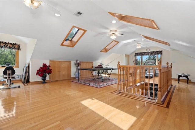 bonus room with vaulted ceiling with skylight, visible vents, and light wood-style flooring