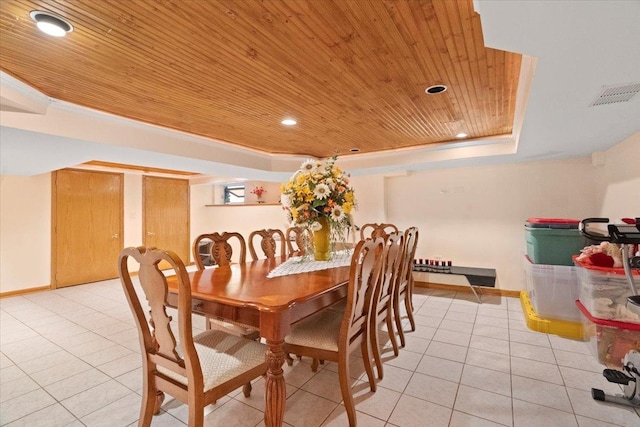 dining space with light tile patterned floors, visible vents, wood ceiling, baseboards, and a raised ceiling