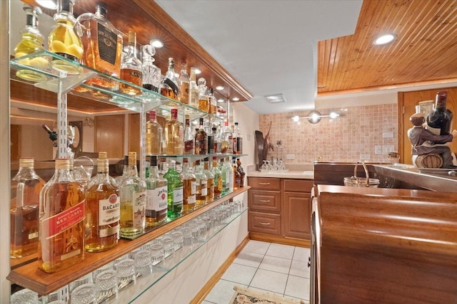 bar featuring light tile patterned flooring, wood ceiling, and wet bar