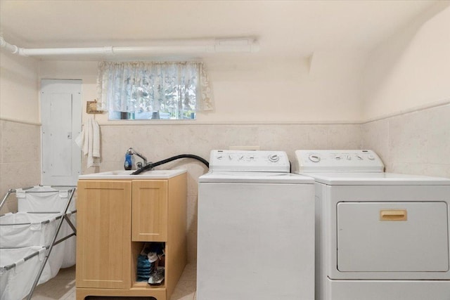 washroom featuring wainscoting, washing machine and clothes dryer, cabinet space, and electric panel