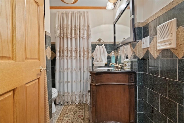 bathroom featuring toilet, a shower with shower curtain, tile walls, and vanity