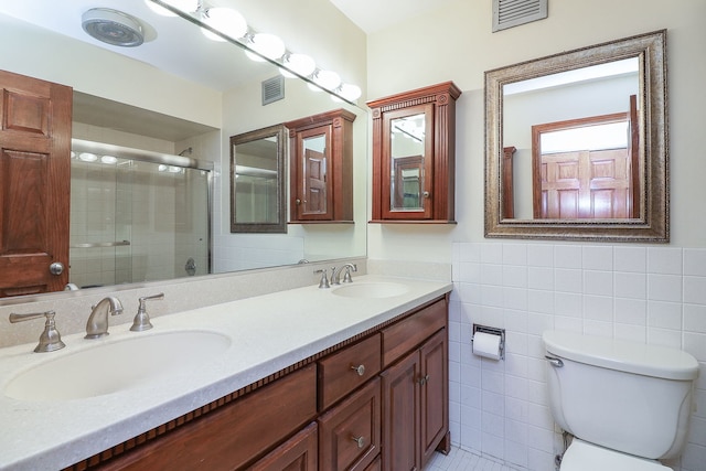 bathroom featuring tile walls, toilet, dual bowl vanity, and tile patterned floors