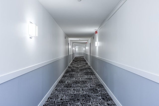 hallway featuring dark colored carpet