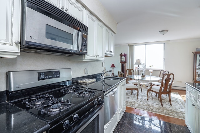 kitchen featuring sink, stainless steel appliances, white cabinetry, and dark hardwood / wood-style floors