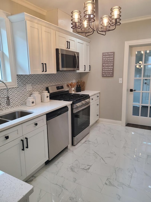 kitchen featuring white cabinetry, sink, stainless steel appliances, pendant lighting, and ornamental molding