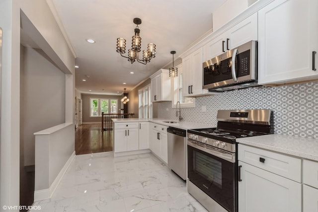 kitchen with an inviting chandelier, kitchen peninsula, appliances with stainless steel finishes, decorative light fixtures, and white cabinetry