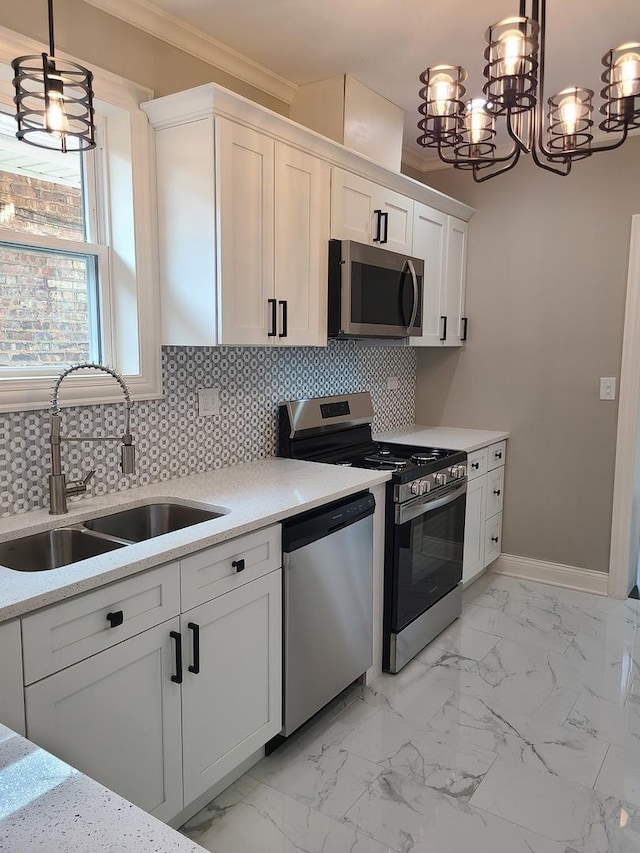 kitchen with sink, tasteful backsplash, decorative light fixtures, white cabinets, and appliances with stainless steel finishes