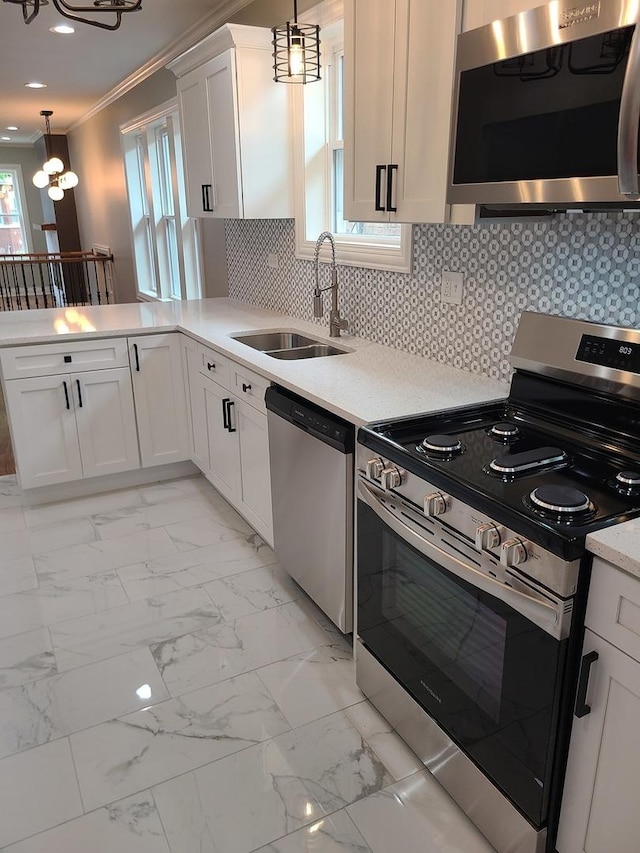 kitchen with white cabinetry, sink, stainless steel appliances, a chandelier, and decorative light fixtures