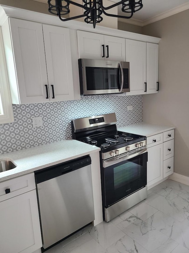 kitchen featuring decorative backsplash, stainless steel appliances, crown molding, sink, and white cabinets