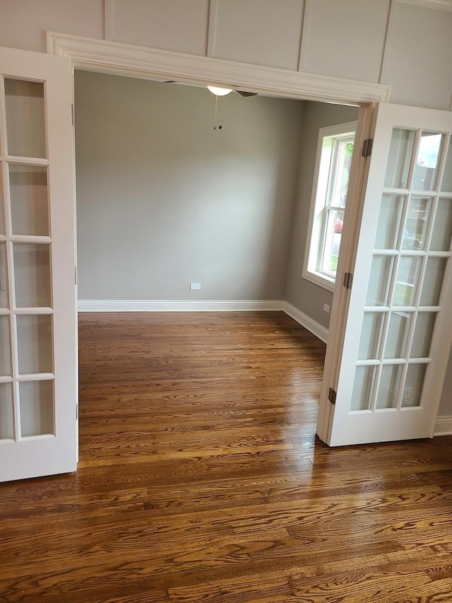 spare room featuring ceiling fan, french doors, and dark wood-type flooring