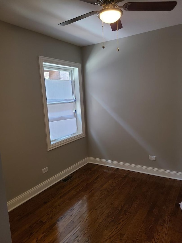 spare room with ceiling fan and dark wood-type flooring