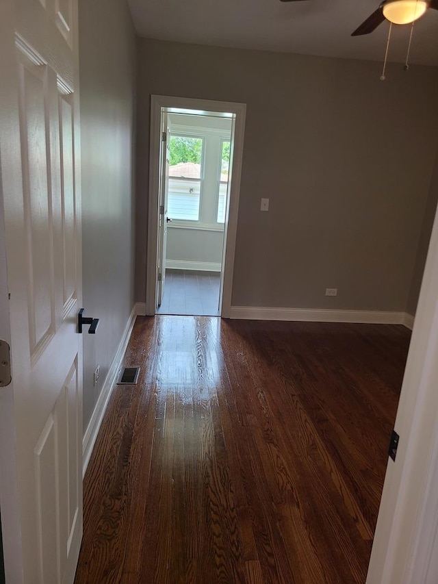 empty room featuring dark hardwood / wood-style flooring and ceiling fan