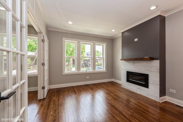 unfurnished living room featuring dark hardwood / wood-style floors, crown molding, and a tiled fireplace