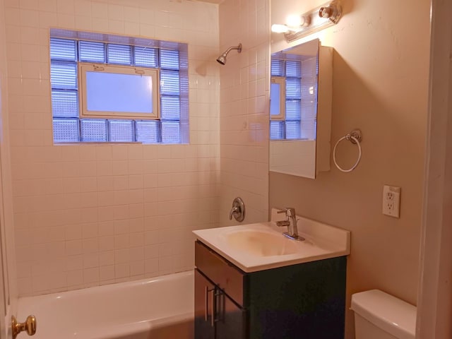 full bathroom featuring vanity, toilet, a wealth of natural light, and tiled shower / bath combo