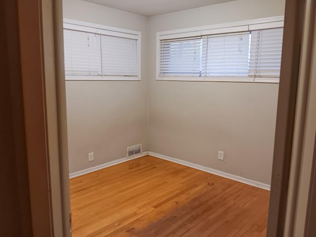 unfurnished room with hardwood / wood-style flooring