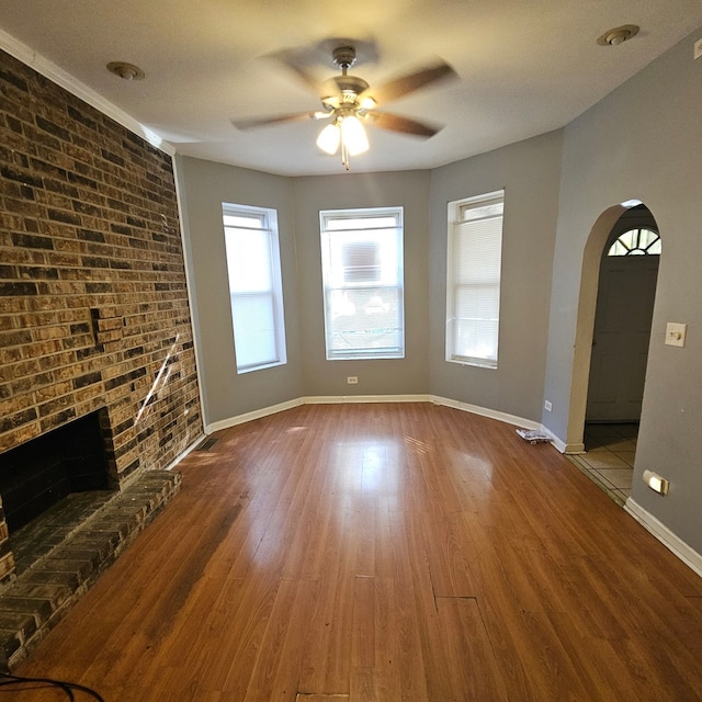 unfurnished living room featuring ceiling fan, light hardwood / wood-style flooring, and a fireplace