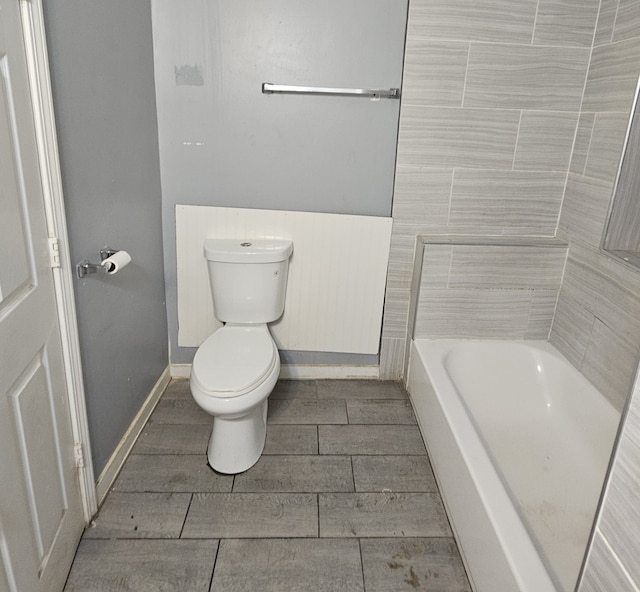 bathroom featuring toilet, a bath, and hardwood / wood-style flooring