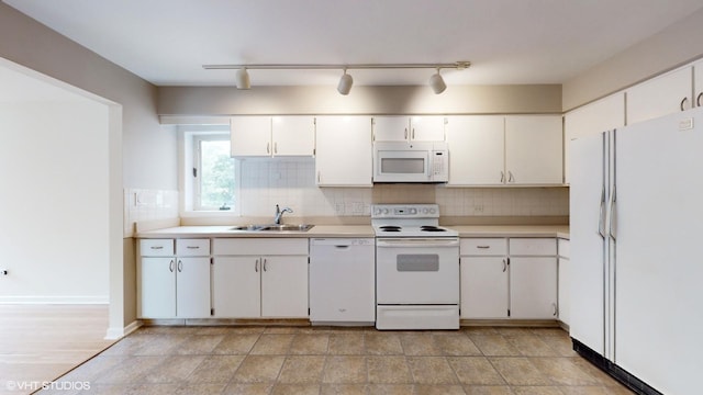 kitchen with white appliances, a sink, white cabinetry, light countertops, and decorative backsplash