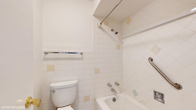 bathroom featuring shower / washtub combination, tile walls, and toilet