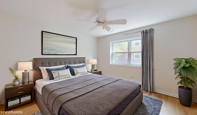 bedroom with light wood-style flooring, baseboards, and ceiling fan