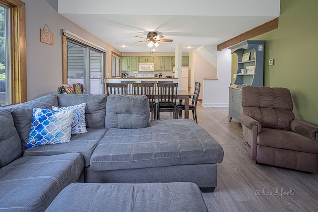 living room with beamed ceiling, wood-type flooring, and ceiling fan