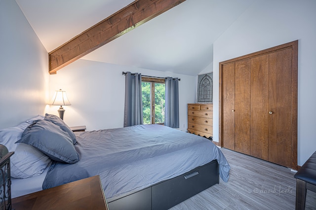 bedroom with a closet, wood-type flooring, beam ceiling, and high vaulted ceiling